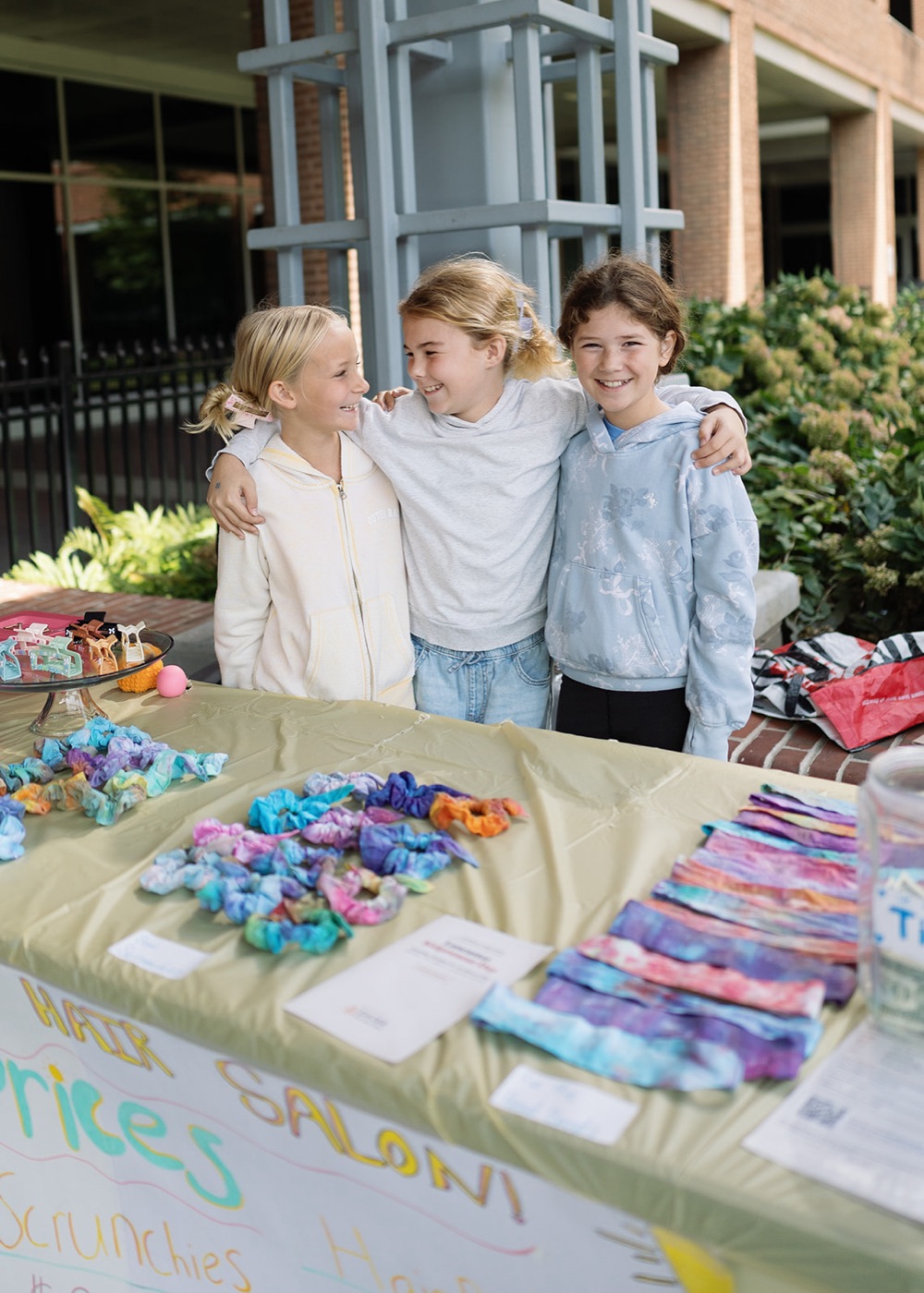 A kid selling hair scrunchies and clips